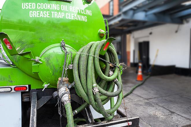 a technician pumping a grease trap in a commercial building in Green Valley, CA